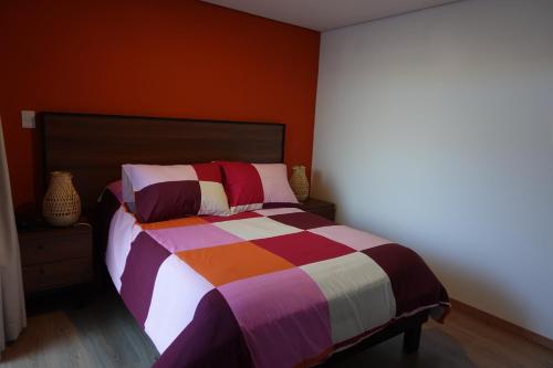 a bedroom with a bed with a colorful striped comforter at Maison Lapinou in Momoxpan