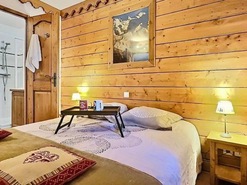 - une chambre dotée d'un mur en bois avec un lit et une table dans l'établissement Beau 4 pièces esprit montagne à Tignes avec balcon, WiFi et casier à ski - FR-1-411-884, à Tignes
