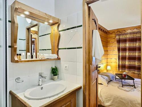 une salle de bain avec un lavabo, un miroir et un lit dans l'établissement Beau 4 pièces esprit montagne à Tignes avec balcon, WiFi et casier à ski - FR-1-411-884, à Tignes