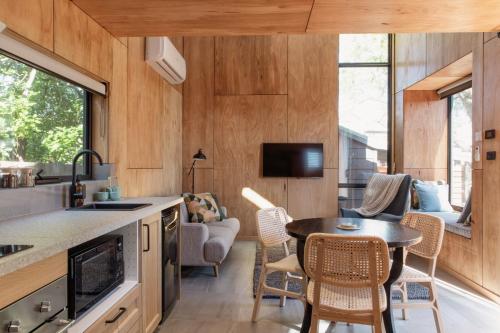 een keuken en een woonkamer met een tafel en stoelen bij Bicheno Garden Cottages in Bicheno