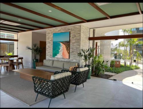 ein Wohnzimmer mit einem Sofa, einem Tisch und Stühlen in der Unterkunft Mana Beach Experience -02Garagens - Aloha 001 in Ipojuca