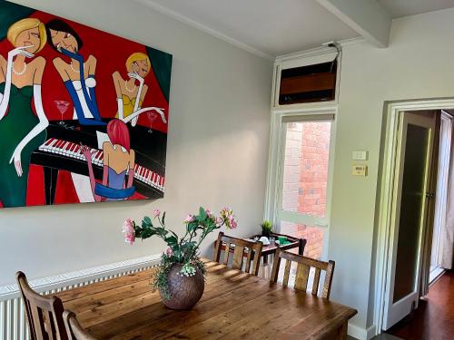 a dining room table with a painting on the wall at Lovely Victorian Terrace - Entire home in Melbourne