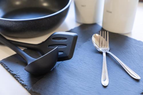 a spoon and fork on a table with a bowl at 丘の上から海が見える一棟貸しヴィラ しまいろ長手 in Nagate