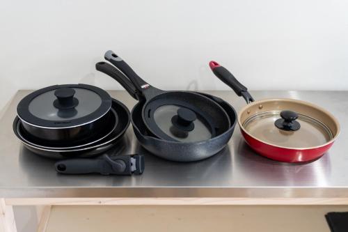 two pots and pans sitting on top of a stove at 丘の上から海が見える一棟貸しヴィラ しまいろ長手 in Nagate