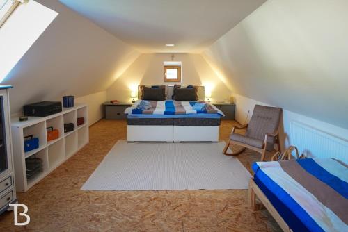 um quarto no sótão com uma cama e uma cadeira em Barinka 