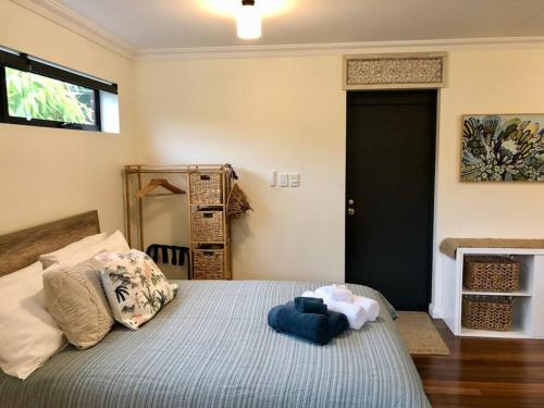 a bedroom with a bed with a blue blanket at The Bungalow - Luxurious & Calm - Beach and Bush Retreat in Valla Beach