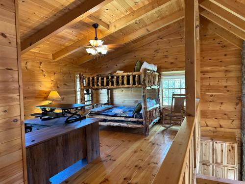 - une chambre dans une cabane en rondins avec des lits superposés dans l'établissement Peaceful Cabin on Lake Sleeps 18 w outdoor kitchen, à Sevierville