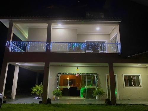 a house with a balcony with christmas lights at Pousada Moriah 700 metrôs Magic City in Suzano