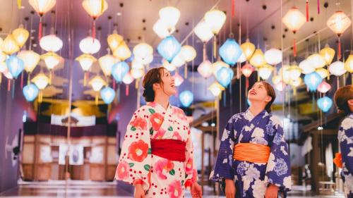 a group of people in kimonos looking up at lights at Art Hotel Osaka Bay Tower in Osaka