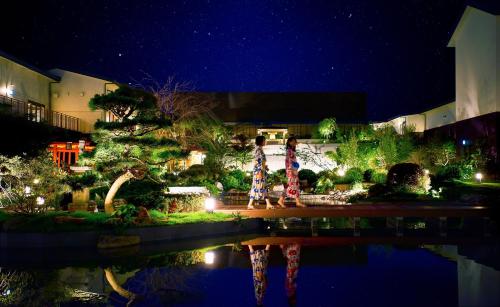 two people walking around a garden at night at Art Hotel Osaka Bay Tower in Osaka