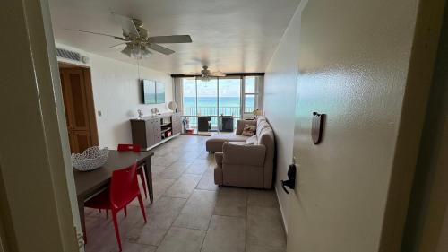 sala de estar con mesa y sala de estar con ventilador de techo. en Ocean Front Condo in Isla Verde! en San Juan