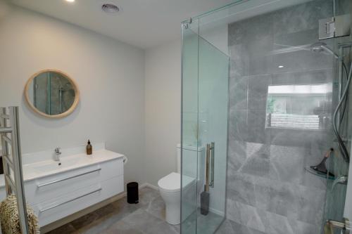 een badkamer met een douche, een toilet en een wastafel bij The Gallery in Rotorua