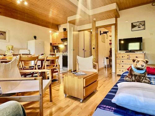 un chien assis sur un lit dans un salon dans l'établissement Charmant T3 avec 2 salles de bain, proche pistes et commodités à Val-d'Isère - FR-1-411-898, à Val dʼIsère