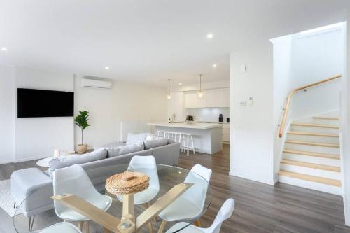 a white living room with a table and chairs at Schnapper Lane in Warrnambool