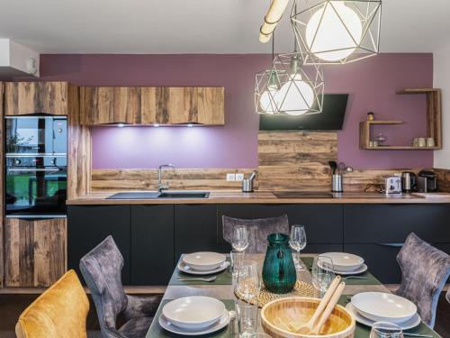 une salle à manger avec une table et des chaises et une cuisine dans l'établissement Appartement moderne avec 3 chambres, terrasse, garage et services inclus à Megève - FR-1-569-131, à Megève