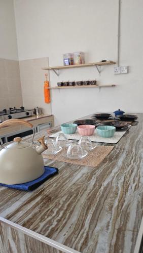 eine Küchentheke mit Schalen und einem Wasserkocher darauf in der Unterkunft Syafeqah Homestay Kimanis Papar in Kimanis