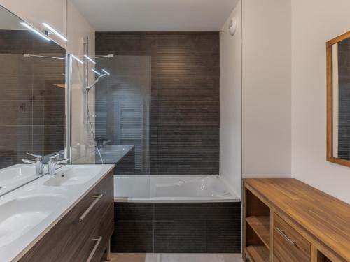 une salle de bain avec une baignoire, un lavabo et une douche dans l'établissement Appartement moderne avec 3 chambres, terrasse, garage et services inclus à Megève - FR-1-569-131, à Megève