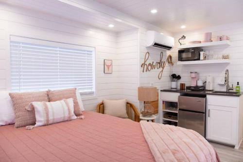 a bedroom with a large bed and a kitchen at New Cowgirl Shipping Container Home in Alpine