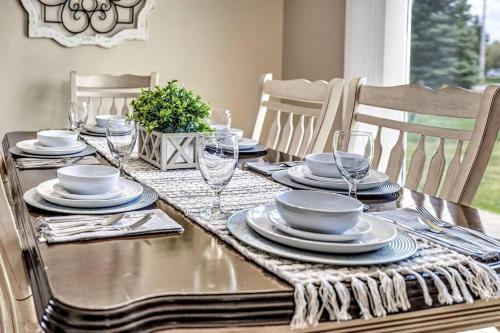 a dining table with plates and wine glasses on it at Serene 3 Bedroom Home, NRM, Wi-fi, Parking, Queen Bed in De Pere