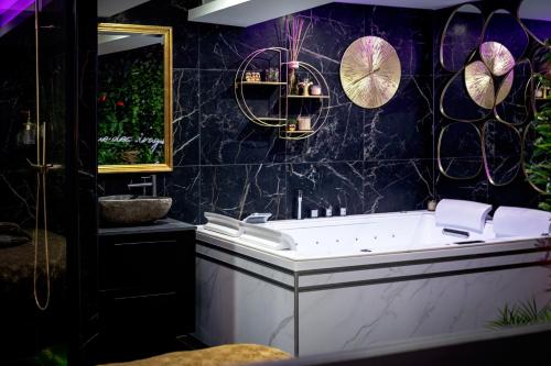 a bathroom with a tub and a sink at Love room “La nuit de rêve” centre historique in Perpignan