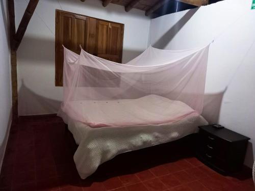 - un lit avec moustiquaire dans l'établissement Resort el refugio, à La Merced