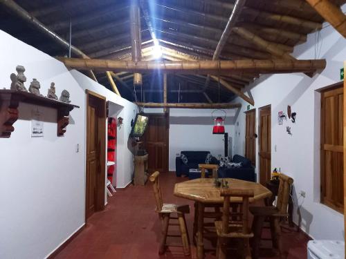 - un salon avec une table et des chaises en bois dans l'établissement Resort el refugio, à La Merced