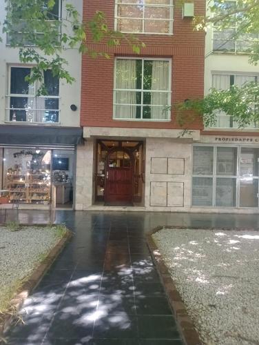 una entrada a un edificio con una puerta roja en DEPARTAMENTO EN LA PERLA en Mar del Plata