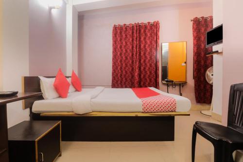 ein Schlafzimmer mit einem Bett mit roten Kissen in der Unterkunft Am Bed And Breakfast in Shillong