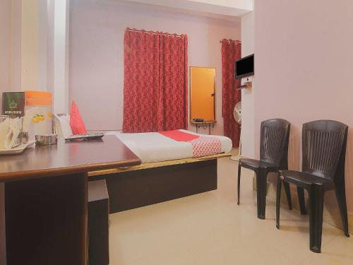 Schlafzimmer mit einem Bett, einem Schreibtisch und Stühlen in der Unterkunft Am Bed And Breakfast in Shillong