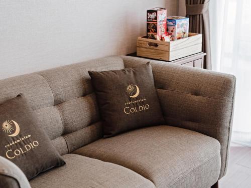 a couch with two pillows on it in a living room at Family Condo Chatan Hills by Coldio Premium in Chatan