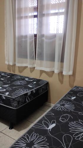 a bedroom with two beds and a window with curtains at HOSTEL VENDA NOVA in Belo Horizonte