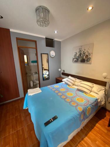 een slaapkamer met een groot bed en een blauw dekbed bij Hostal Pacasmayo Beach in Pacasmayo