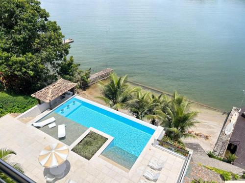 een uitzicht over een zwembad naast het water bij Oásis Beach House in Angra dos Reis