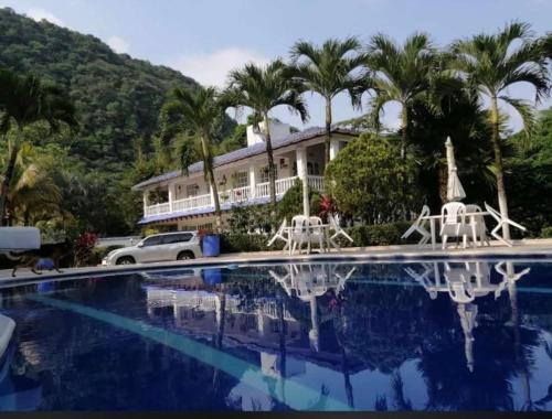 a house with palm trees and a swimming pool at Quinta El Diamante in Villavicencio