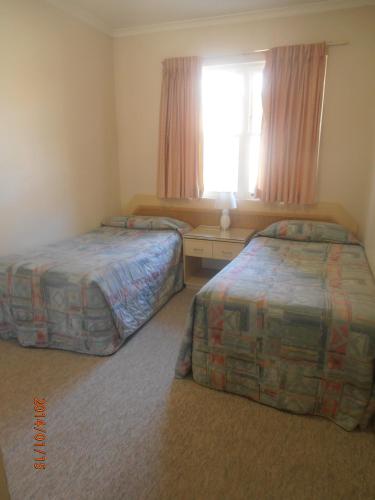 a hotel room with two beds and a window at Beautiful, inner city, renovated top floor 2-bedroom apartment in Canberra