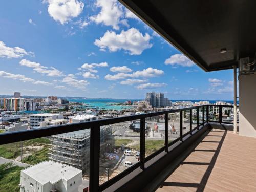 a balcony with a view of the beach and buildings at Family Condo Chatan Hills by Coldio Premium in Chatan