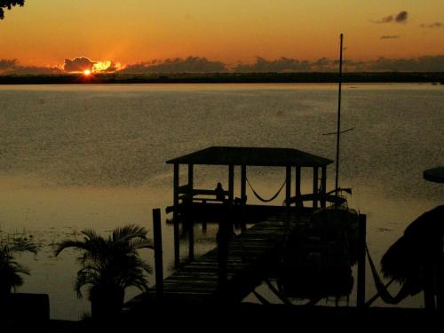 a dock on a body of water at sunset at Tropic Bacalar in Bacalar