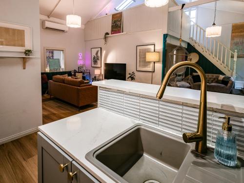 a kitchen with a sink and a living room at WB Clare Valley Cottage w Loft in Clare