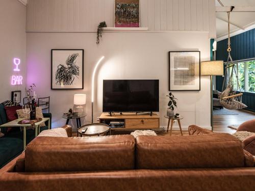 ein Wohnzimmer mit einem Sofa und einem Flachbild-TV in der Unterkunft WB Clare Valley Cottage w Loft in Clare