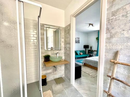 a bathroom with a shower and a sink and a bed at La Monstera Rooms in Sestri Levante