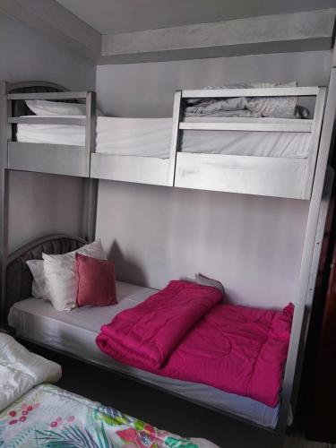 a bedroom with two bunk beds with red sheets at Porto Said in Port Said