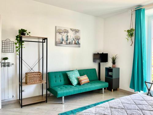 a living room with a green couch and a television at La Monstera Rooms in Sestri Levante
