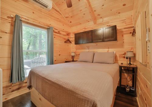 Ani Cabin Tiny Home Bordered By National Forest في تشاتانوغا: غرفة نوم بسرير في كابينة خشبية