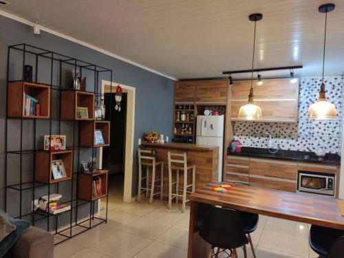 a kitchen with a table and a bar in it at Casa na praia p aproveitar com a família e amigos in Capão da Canoa