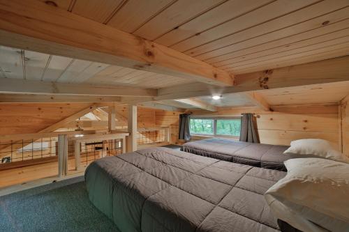a bedroom with two beds in a log cabin at Ernie Cabin Wauhatchie Woodlands Tiny Cabin in Chattanooga