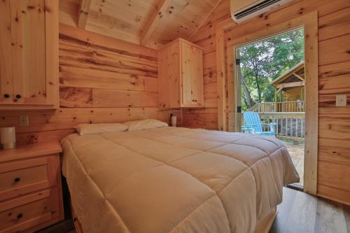 ein Schlafzimmer mit einem Bett in einem Blockhaus in der Unterkunft Bryce Cabin Lookout Mtn Tiny Home W Swim Spa in Chattanooga