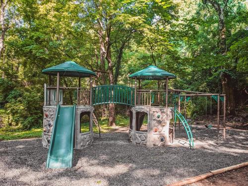 a playground in a park with two play equipment at Bryce Cabin Lookout Mtn Tiny Home W Swim Spa in Chattanooga