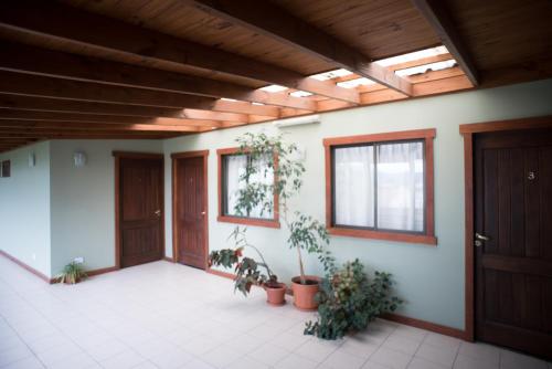 an empty room with two doors and potted plants at Hotel Austral Ushuaia in Ushuaia