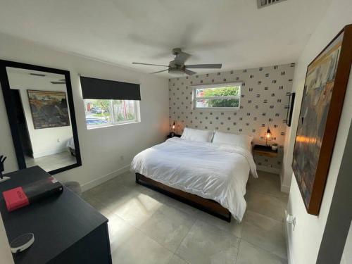 a bedroom with a bed and a ceiling fan at Modern pool home on the lake near Hardrock FLL airport in Davie
