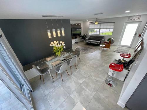 a living room with a table and chairs and a couch at Modern pool home on the lake near Hardrock FLL airport in Davie
